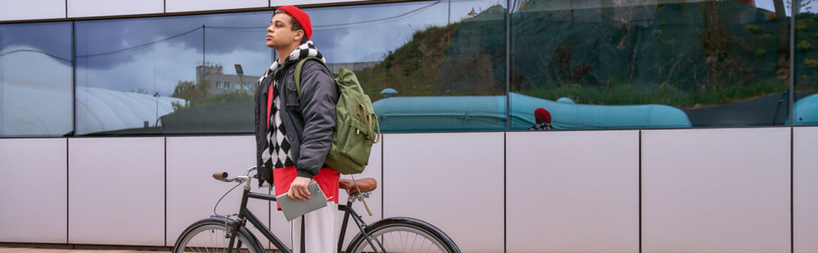 Stylish young man riding bicycle through city on a vibrant day