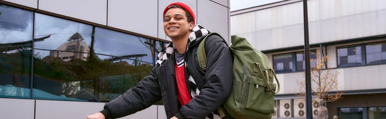 Stylish young man enjoys a vibrant day in the city as he rides his bike to class © LIGHTFIELD STUDIOS