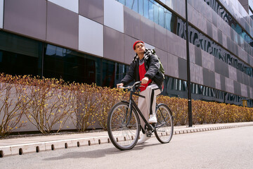 Fototapeta premium Handsome young man rides bicycle through stylish city landscape on a bright sunny day