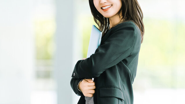 ノートパソコンを持つ女性・ビジネスウーマン, Businesswoman Holding a Laptop Computer