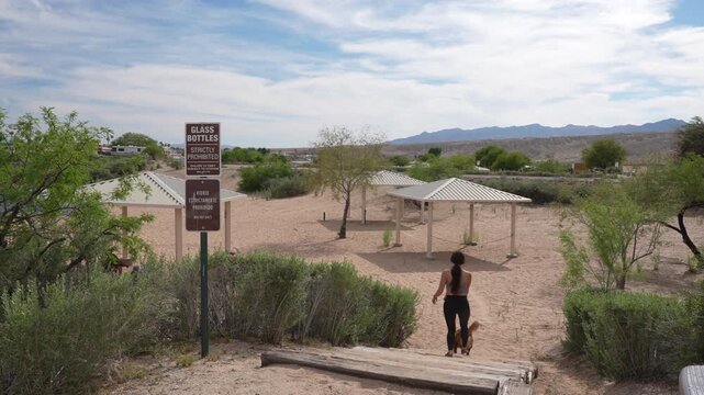 Woman With Dog Walking at Beach Entrance, Big Bend of Colorado River Recreational Area, Laughlin Nevada USA