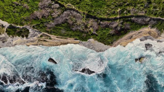 Aerial view of Kurnell cliffs with crashing ocean waves and lush coastal vegetation in Sydney, New South Wales, Australia.