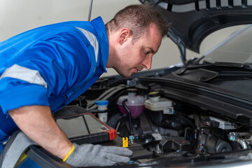 Fototapeta premium Electric Vehicle Mechanic Examining Engine Bay With Diagnostic Tool