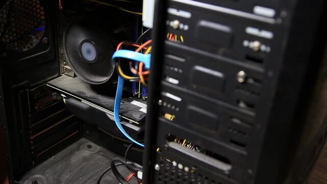 Internal view of desktop computer components, revealing central processing unit fan, graphics processing unit, motherboard circuitry, and power cables within system unit chassis for personal computing