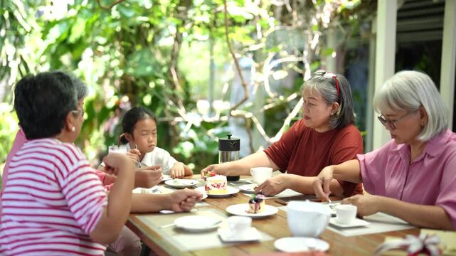 Group of older friends enjoys dining together at restaurant while ordering meals and sharing conversations. Friendship, active aging and joyful retirement create warm social experiences.