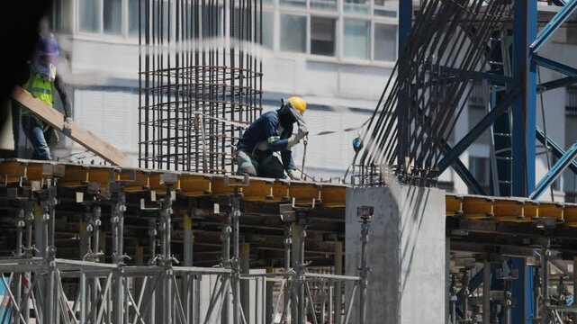 Construction worker builds structure in urban area during daytime
