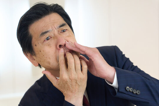 トイレで鼻毛のチェックをするビジネスマン