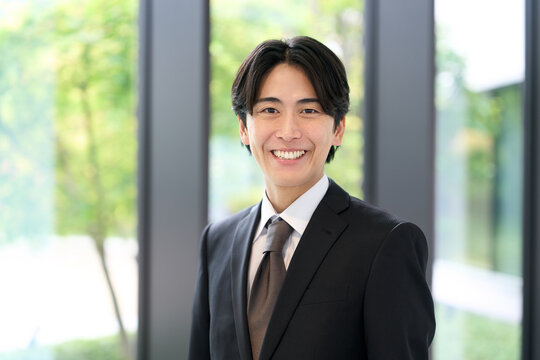 笑顔で立つアジア人ビジネスマン