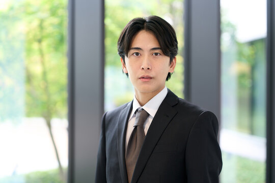 真剣な表情で立つアジア人ビジネスマン