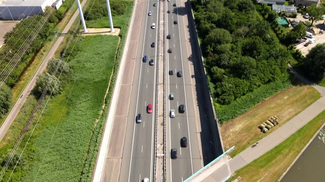 Aerial view of highway traffic flowing through green landscapes and rural surroundings near Den Hoorn, South Holland, Netherlands.