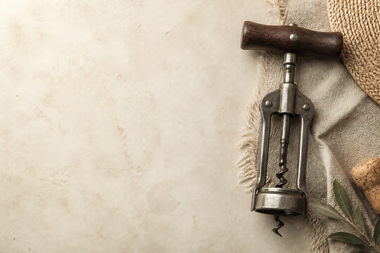 A vintage meat tenderizer tool rests on a textured fabric surface against a light, aged background.