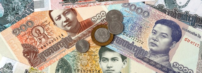 Cambodian riel money banknotes and coins on table. Cambodia cash bills of KHR currency © Viktor