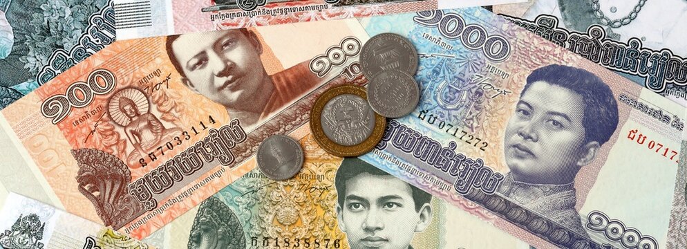 Cambodian riel money banknotes and coins on table. Cambodia cash bills of KHR currency