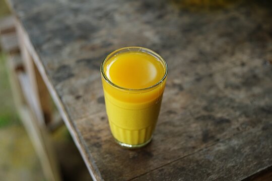 Healthy traditional Indonesian herbal jamu kunyit asem drink served in a glass with natural ingredients and wellness concept.