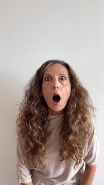 C&aacute;mara lenta de mujer blanca de 45 a&ntilde;os muy sorprendida abriendo ojos y boca