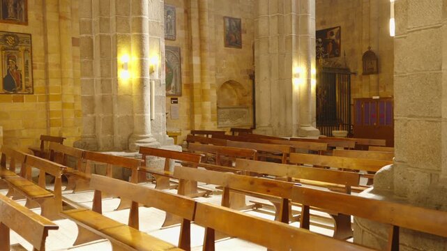 A slow cinematic camera move glides through the golden lit stone interior of a medieval Gothic cathedral