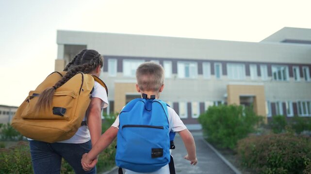 Children heading to school. Siblings with backpacks holding hands. Excited children on their way to fun day. pupils enjoying school. Back to school excitement. Children school fun for every pupil.
