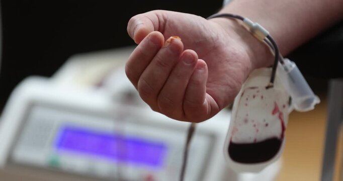 Blood donor hand detail during blood donation procedure