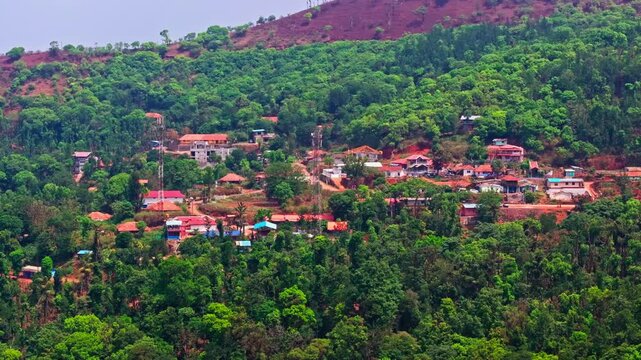 Mountain village houses with road, signal tower and dense forests at Attigundi village, Dattatreya Peeta, Chikmagalur, Karnataka, india. day time, trucking shot, drone shot, 4k.