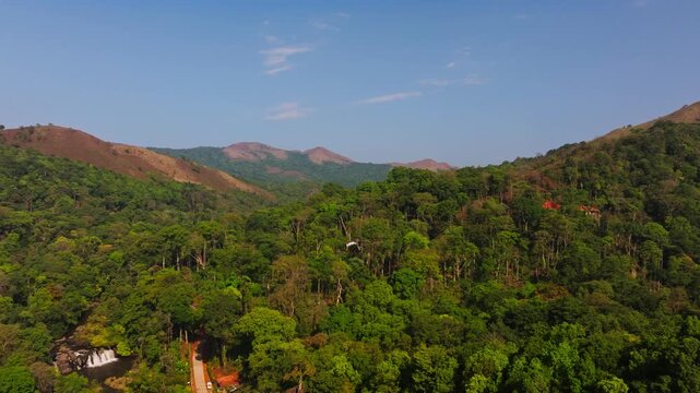 Kote Betta mountains peak with dense forest, sky and Kote Abbey DIVINE Waterfalls at mukkodlu, coorg, madikeri, karnataka, india. day time, circle shot, drone shot,4k.