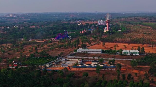 Wide view of wonderla with resort, trees, haze and venture lands at Bannikuppe, Bangalore, karnataka, india. day time, push in shot, drone shot, 4k.