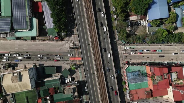 Aerial top-down view of EDSA overpass crossing Col Bonny Serrano Avenue, with traffic moving through a four-way Metro Manila intersection - Philippines