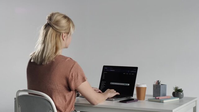 Woman programming using generative ai tools on laptop
