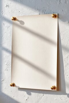 Minimal vertical poster mockup pinned to textured wall with blank paper and soft sunlight shadows
