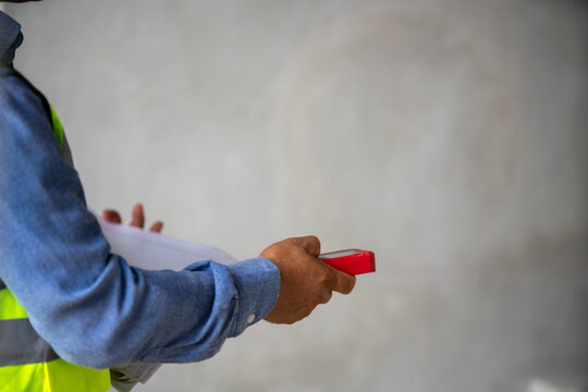 Construction worker using mobile device for project management and technical assessments on job site