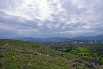 Obraz premium Rolling green hills and dramatic clouds create a serene landscape in a rural