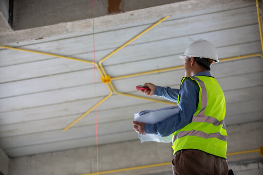 Construction worker utilizing a laser level to achieve precise measurements during a building project