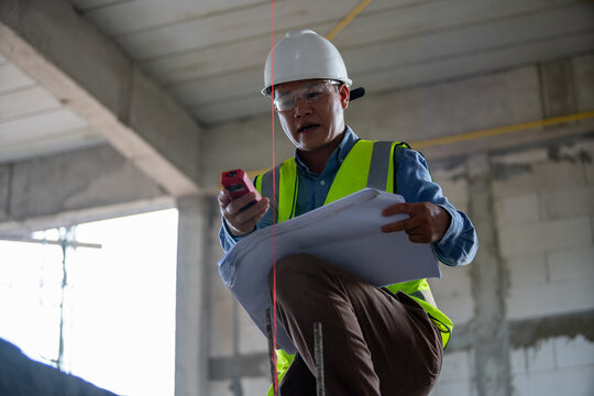 Construction worker using technology to review plans on a job site with safety gear and professional attire