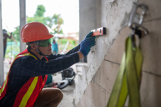 Construction professional utilizing a leveling tool to verify precise measurements at a job site