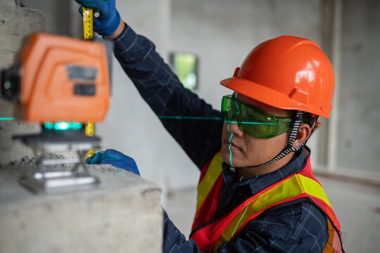 Construction professional utilizing a laser level to ensure accurate measurements at the work site