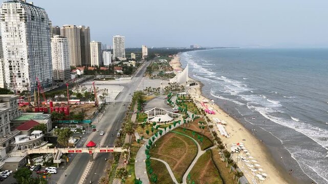 Coastal Vung Tau view from above, with waves, coastline, streets, coconut trees and Tao Phung mountain in Vietnam
