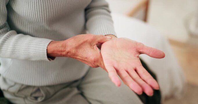 Home, hands and senior woman with wrist pain for arthritis, nerve compression and inflammation. Retirement, elderly person and muscle massage on bed with discomfort, rheumatism risk and osteoporosis