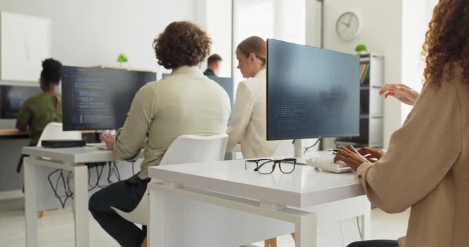 Developers programmers team coding collaboration in office. Programmers type at monitors as colleagues debug code, showing agile workflow in a workplace. Modern teamwork and productivity concept.