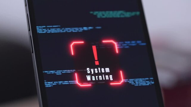 Smartphone display shows system warning, running source code, data, cyber crime, unauthorized access. Warning sign on the screen, mobile device is hacked, network security, privacy, safety.