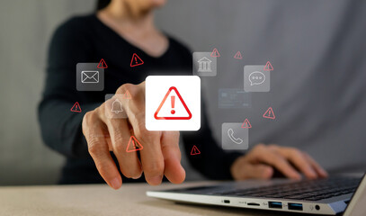 Businesswoman touching warning alert icon on laptop screen for cyber security and system error concept © MAUNG