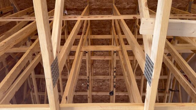 Looking up at an unfinished residential roof during the structural skeleton stage highlighting high-quality craftsmanship. Perfect for subcontractor inspection and property development projects.