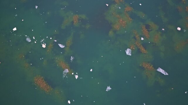 Drone shot of calm Great Lakes waters with frozen ice plates arranged in beautiful natural patterns.