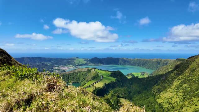 Cinematic view from the Grota do Inferno hiking trail on Sao Miguel Island Azores Portugal overlooking Sete Cidades with emerald crater lakes lush volcanic slopes and the Atlantic Ocean