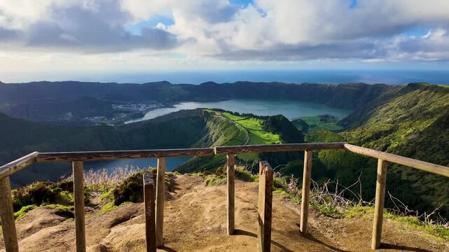 Cinematic view from the Grota do Inferno viewpoint on Sao Miguel Island Azores Portugal featuring dramatic clouds golden light Sete Cidades crater lakes and volcanic landscapes