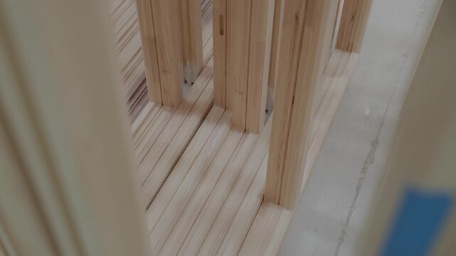 Stack of unfinished wood window frames stored in a manufacturing factory, showcasing organized timber components ready for assembly or finishing