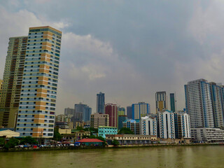 Obraz premium Modern skyline of Manila, Philippines, viewed across the Pasig River. High rise buildings and dense urban development reflect the energy of a fast growing Southeast Asian metropolis.