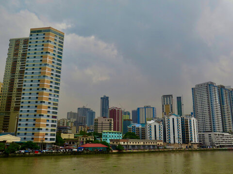 Modern skyline of Manila, Philippines, viewed across the Pasig River. High rise buildings and dense urban development reflect the energy of a fast growing Southeast Asian metropolis.