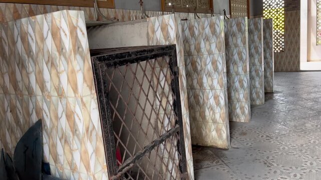 Row of public toilet stalls with patterned ceramic walls