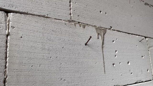 Close Up of Single Nail on Cracked Autoclaved Aerated Concrete