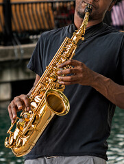 Fototapeta premium Close up of a man playing a saxophone on the street