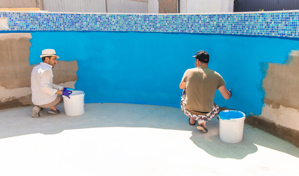 Paints the pool with blue paint. Selective focus.